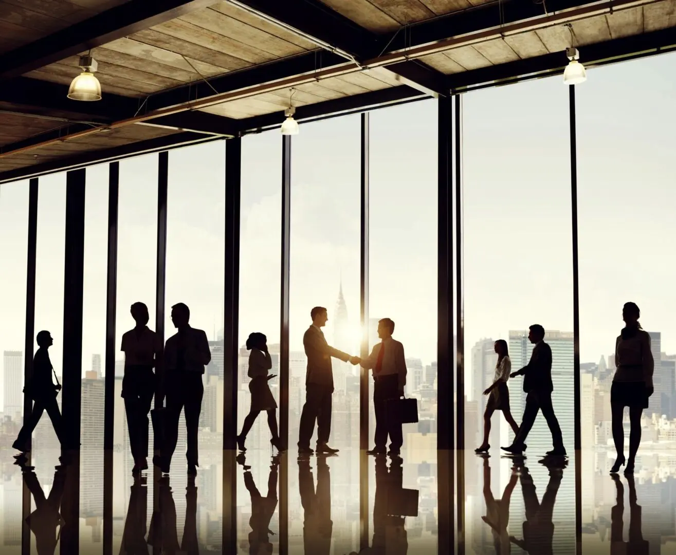 A group of people standing in front of large windows.